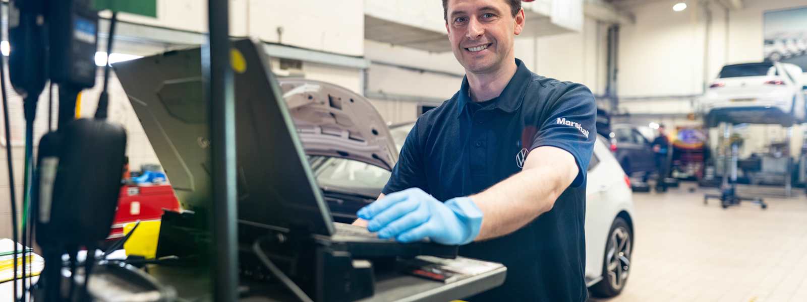 Marshall technician using a diagnostic laptop in a workshop